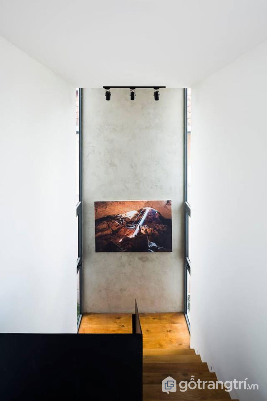 THỦ ĐỨC HOUSE - KIẾN TRÚC HIỆN ĐẠI KẾT HỢP ĂN Ý VỚI KHÔNG GIAN XANH — GỖ TRANG TRÍ BỨC TRANH NGHỆ THUẬT ĐƯỢC TREO KHÁ THẤP SO VỚI CHIỀU CAO BỨC TƯỜNG LÀM ĐIỂM NHẤN CHO NGÔI NHÀ THEO KIẾN TRÚC HIỆN ĐẠI - ẢNH: HIROYUKI OKI