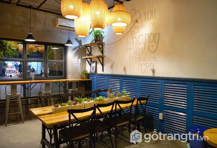 Phong cách nội thất retro được thể hiện qua không gian bên trong với đèn lồng trang trí, bộ bàn ghế cao, sát cửa kính (Ảnh: Internet)